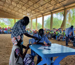 Mr. Adult (a visually impaired) showcasing his mastery of braille in a celebration held at Doro Refugee camp