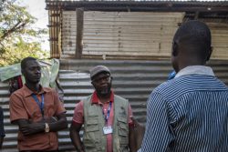 Emmanuel talking to JRS staff during a home visit